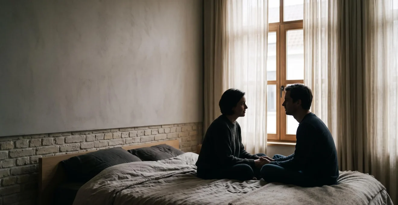 Deux mains qui se touchent doucement près d'une fenêtre lumineuse, symbole du dialogue et de la confiance dans le consentement au sein du couple